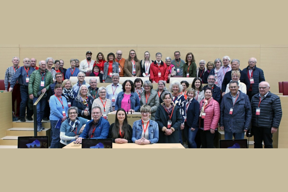 Auf den Stühlen im Plenarsaal Platz genommen